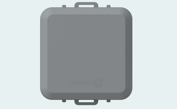 Der Square Tracker Xtreme: ein graues dichtes Gehäuse mit je einer Lasche an Ober- und Unterkante für die Montage mit Kabelbinder oder Rahmen, das Sensative-Logo auf der unteren Fläche